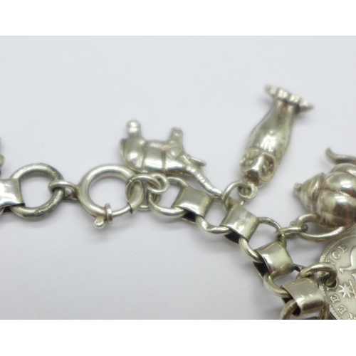 932 - A white metal charm bracelet, 50g