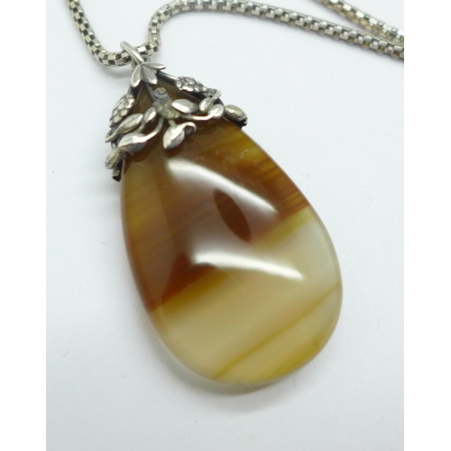 938 - An agate pendant, set in white metal on a modern silver chain, Arts and Crafts in the style of Dorri... 