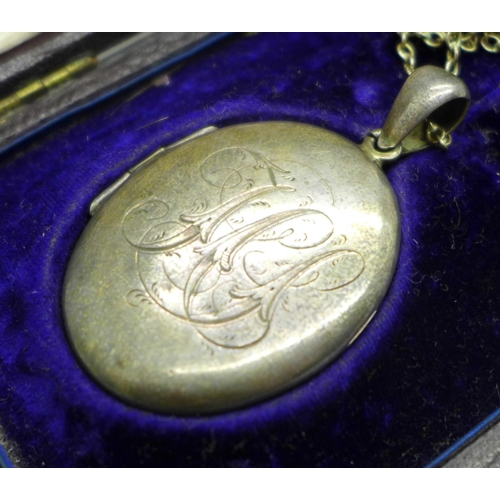 955 - A white metal locket with chain, locket bears monogram, with associated case, locket 4cm x 3cm