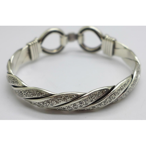 973 - A large silver and diamond encrusted bangle, approximately 2carat diamond weight, 88g