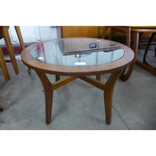 105 - A teak and glass topped circular coffee table