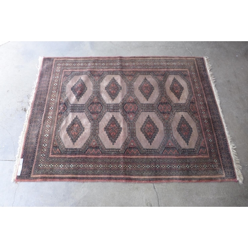 188 - An eastern terracotta ground rug, 174 x 126cms