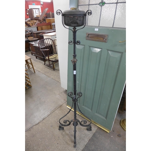 312 - An Art Nouveau wrought iron and copper floor standing oil lamp