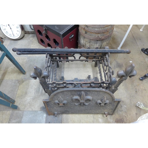 327 - A pair of wrought and cast iron andirons and fire grate