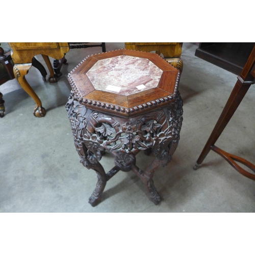 69 - A Chinese padouk wood and marble topped jardiniere stand