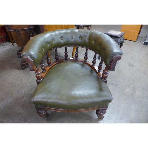 71 - An early Victorian mahogany and green faux leather tub shaped library chair