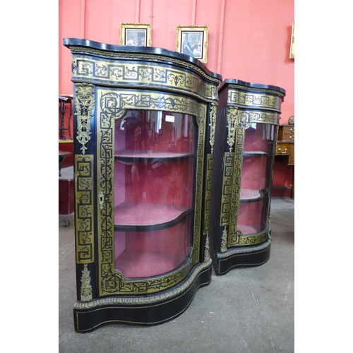 73 - A pair of Boulle style ebonised and brass inlaid serpentine corner cabinets