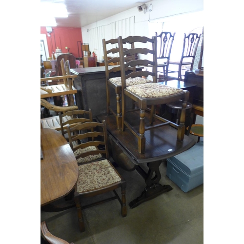 328 - An oak drop leaf table and four ladderback chairs