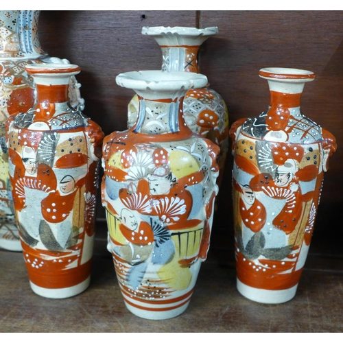 702 - A collection of 20th Century Meiji revival period china comprising three vases decorated with samura... 