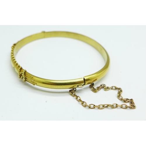 1062 - A 15ct gold and three stone set bangle with box, 7.4g