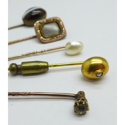 1067 - Five stick pins including yellow metal and tigers eye