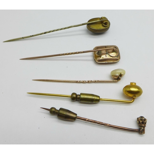 1067 - Five stick pins including yellow metal and tigers eye