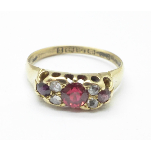 1129 - A 18ct gold, garnet and diamond ring, 2.9g, O