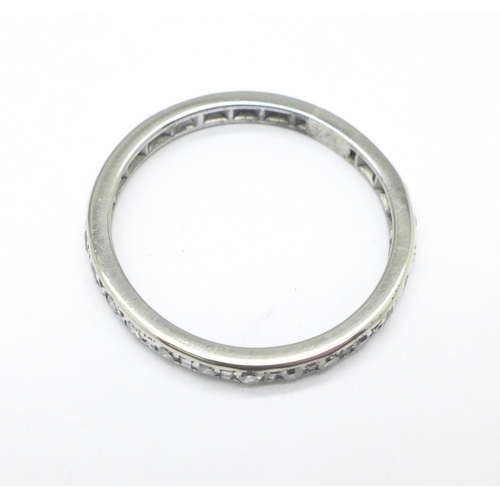 1133 - A white metal and diamond half eternity ring, tests as platinum, 3.4g, S