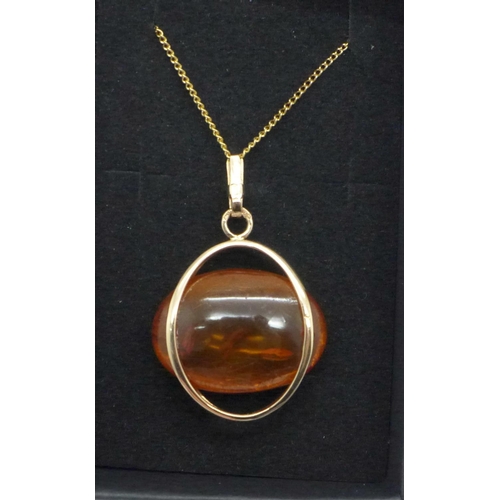 1137 - An amber and yellow metal pendant on chain, marked 583, 6.6g