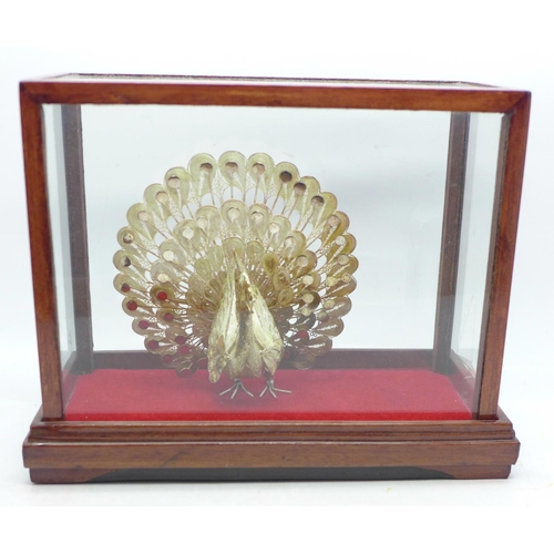 623 - A .925 silver peacock in display case, 12cm