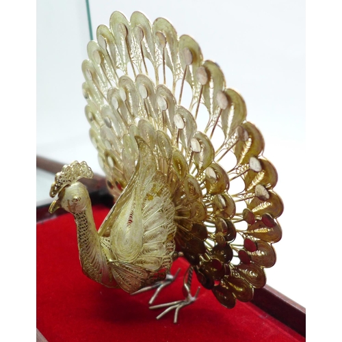 623 - A .925 silver peacock in display case, 12cm