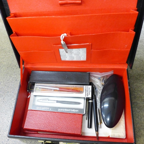 714 - A fitted leather writing case, an Aston & Mander ivory ruler, pens, etc.