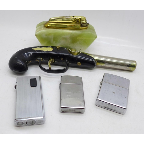 718 - A novelty pistol table lighter, an onyx table lighter and three others