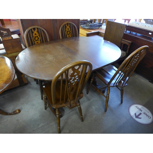 261 - An Old Charm oak extending dining table and four chairs