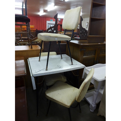 319 - A Formica drop leaf kitchen table and three chairs