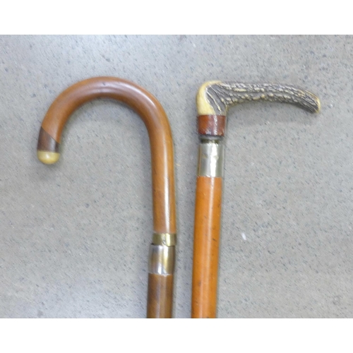 809 - Two walking sticks, one with an internal measuring stick, one with an umbrella