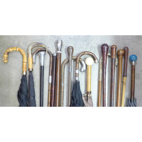 814 - A collection of sixteen walking sticks and umbrellas, three with silver tops, one with 18ct gold dec... 