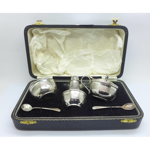 834 - A cased Art Deco three piece cruet set, with salt spoons, Bakelite liners, Birmingham 1954, gross we... 