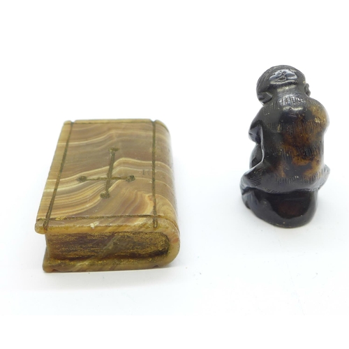 861 - A carved stone figure of a chimpanzee holding a nut and a carved agate Bible