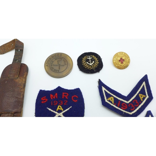 880 - A 1940's wristwatch, shooting badges and other badges