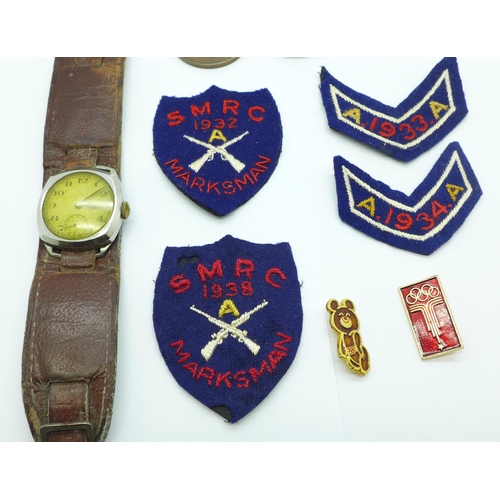 880 - A 1940's wristwatch, shooting badges and other badges