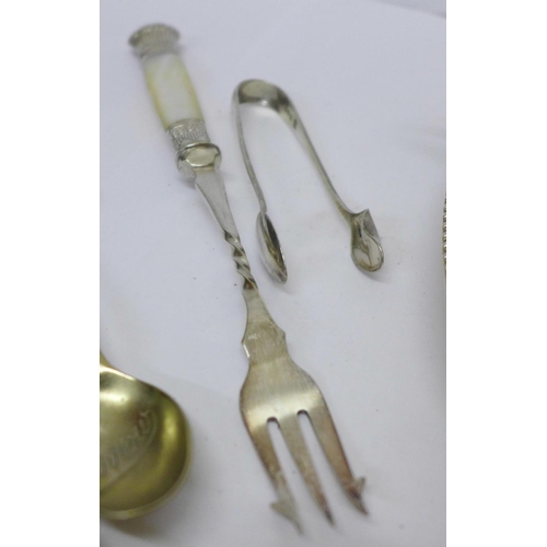 933 - Silver sugar tongs, 11.5g, a silver mounted fork and other plated ware