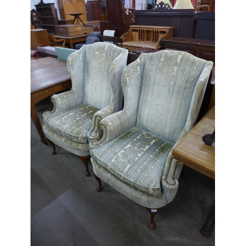 242 - A pair of 1930's Queen Anne style walnut and upholstered wingback armchairs