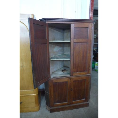 227b - A George III mahogany freestanding splay front corner cupboard