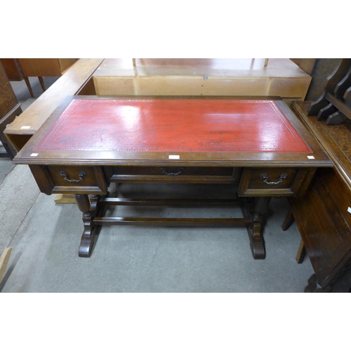 183 - An oak and red leather topped three drawer desk