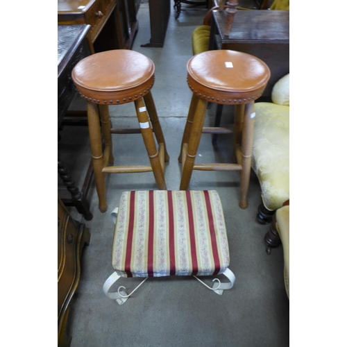 194 - A pair of oak and leather topped bar stools and a small wrought steel stool