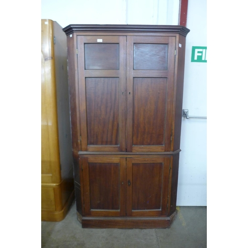 227b - A George III mahogany freestanding splay front corner cupboard