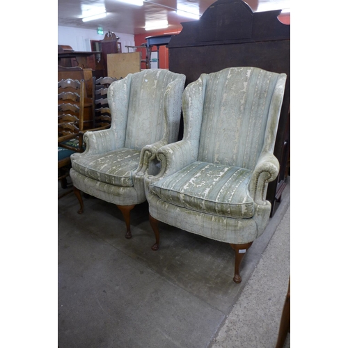 242 - A pair of 1930's Queen Anne style walnut and upholstered wingback armchairs