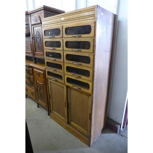 45 - A mid 20th Century oak haberdashery shop cabinet, 172cms h, 94cms w , 48cms d