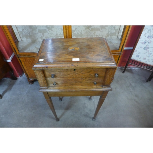 54 - An Edward VII oak canteen of cutlery cabinet on stand, including a quantity of plated flatware