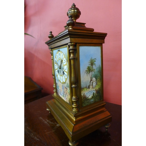 61 - A 19th Century French gilt metal mantel clock, with painted porcelain panels, 35cns h