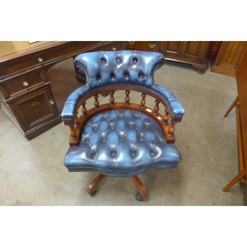 76 - A mahogany and blue leather revolving desk chair