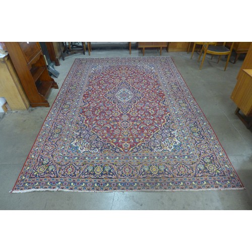 73 - A large red ground rug, 368 x 247cms