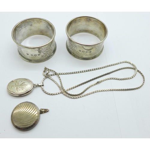 1124 - A pair of silver napkin rings and two silver lockets and a chain, 56g