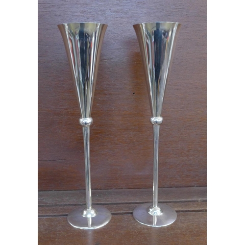 1134 - A pair of tall silver wine flutes with gilt interiors, by Carrs, cased, 470g