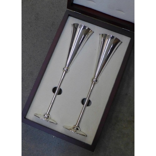 1134 - A pair of tall silver wine flutes with gilt interiors, by Carrs, cased, 470g