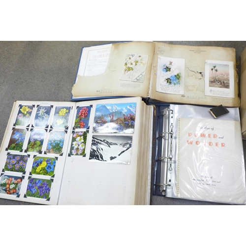 770 - A box of ephemera containing a vintage postcard album, an Atlas, photographs and other ephemera