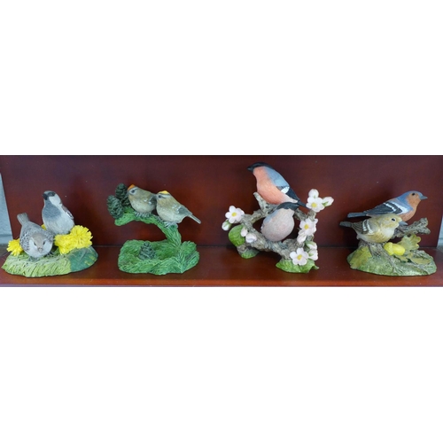 824 - A collection of twelve Danbury Mint bird figures on a display rack