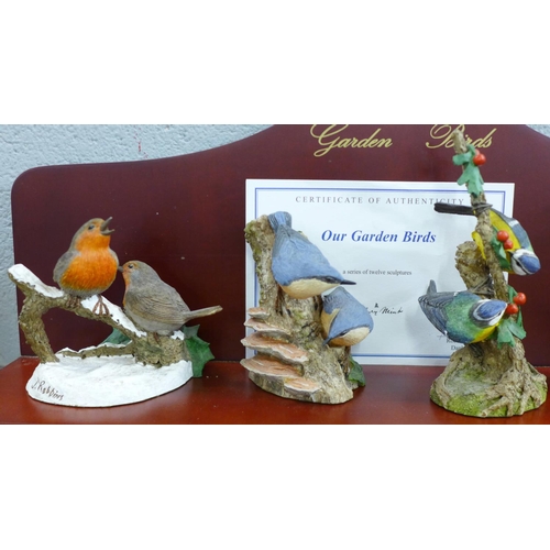 824 - A collection of twelve Danbury Mint bird figures on a display rack