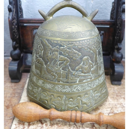 830 - An oriental metal bell on a carved wooden frame